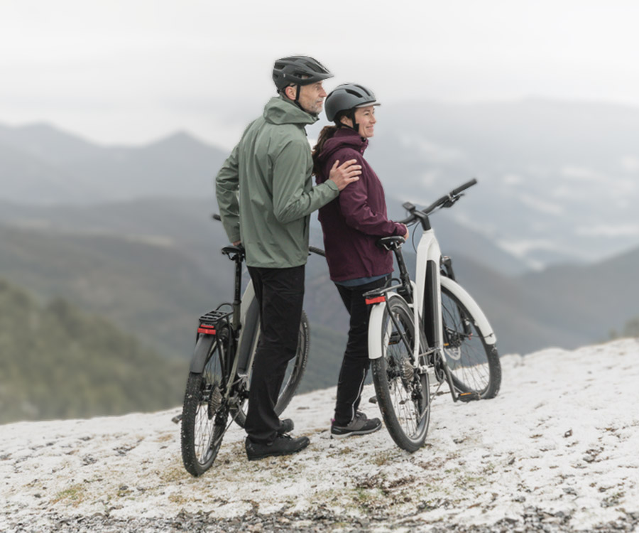 mand og dame med står med elcykel