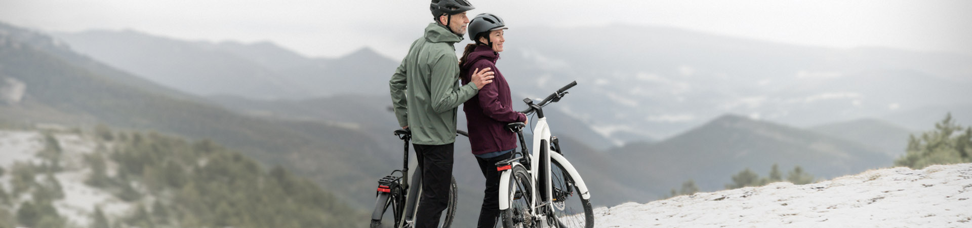 mand og dame med står med elcykel